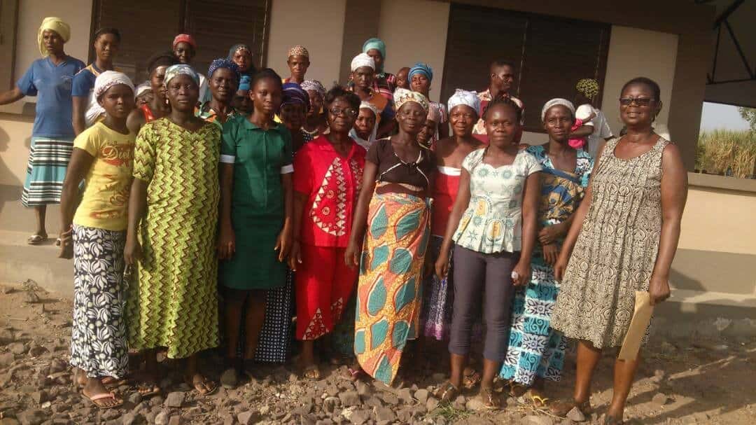 Public Health Nurse Elizabeth Sarfo Adu (in red) surrounded by ARC staff and villagers